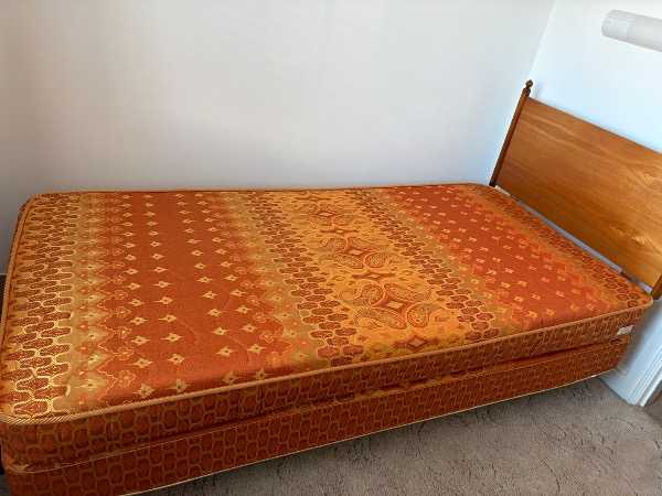 Single bed with wooden headboard
