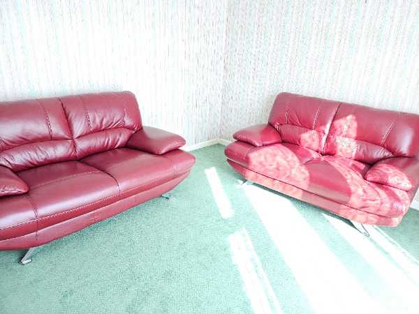 Two burgundy leather three seater sofas