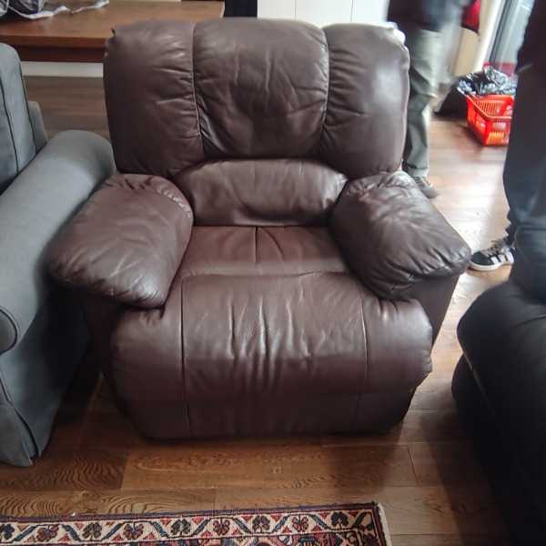 Comfortable brown leather recliner armchair in good condition.
